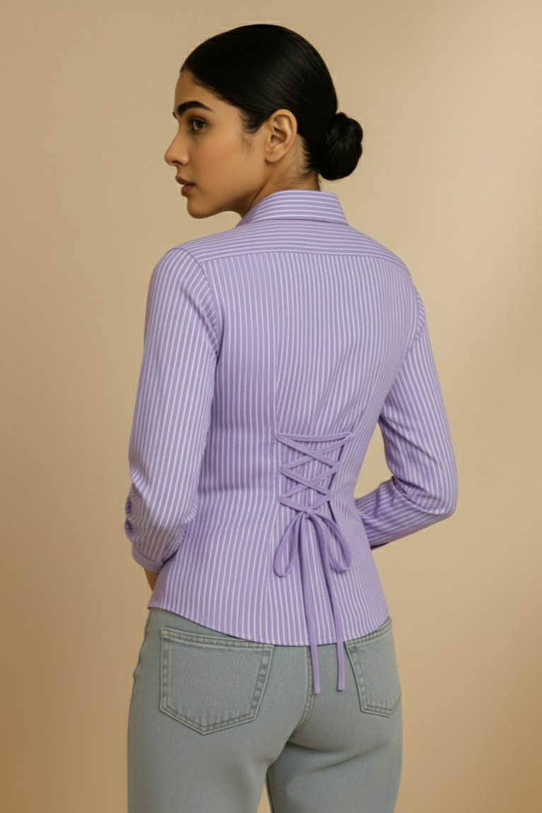 Woman wearing a purple striped shirt with a tie detail at the back on a beige background